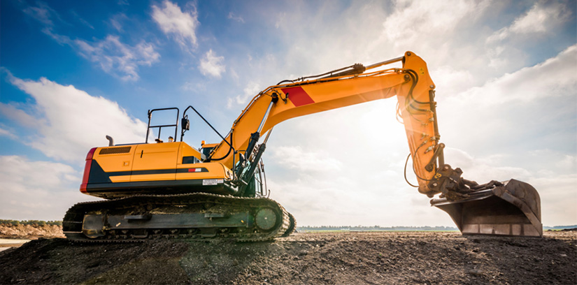 Yellow excavator with sun in background.